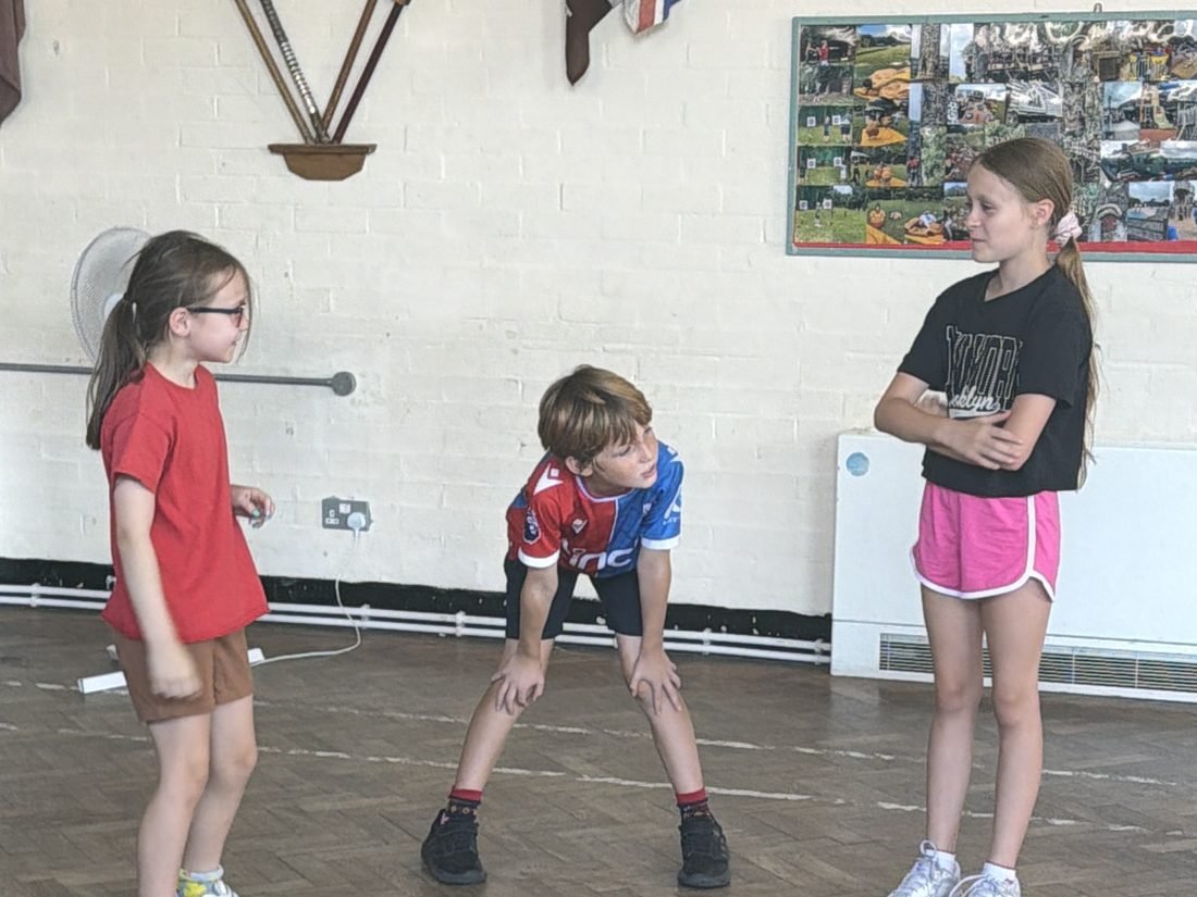 Young performers rehearsing a routine together in a hall
