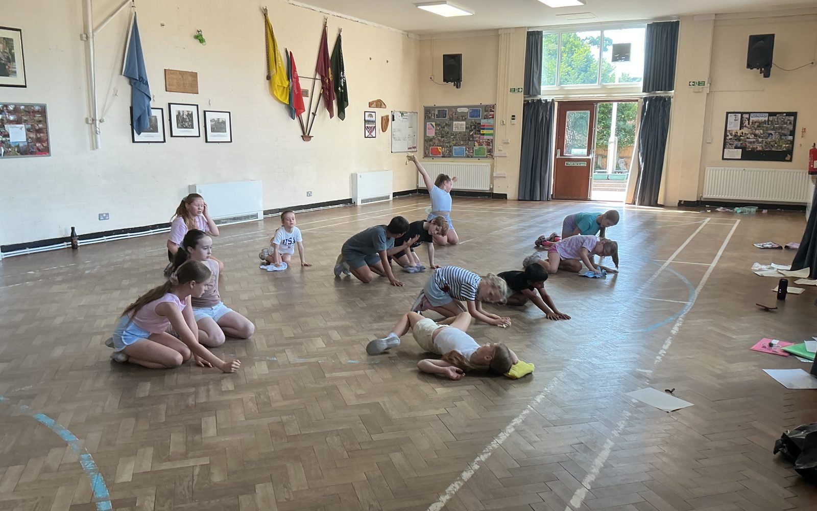 Young performers working together on the floor of a hall during a session
