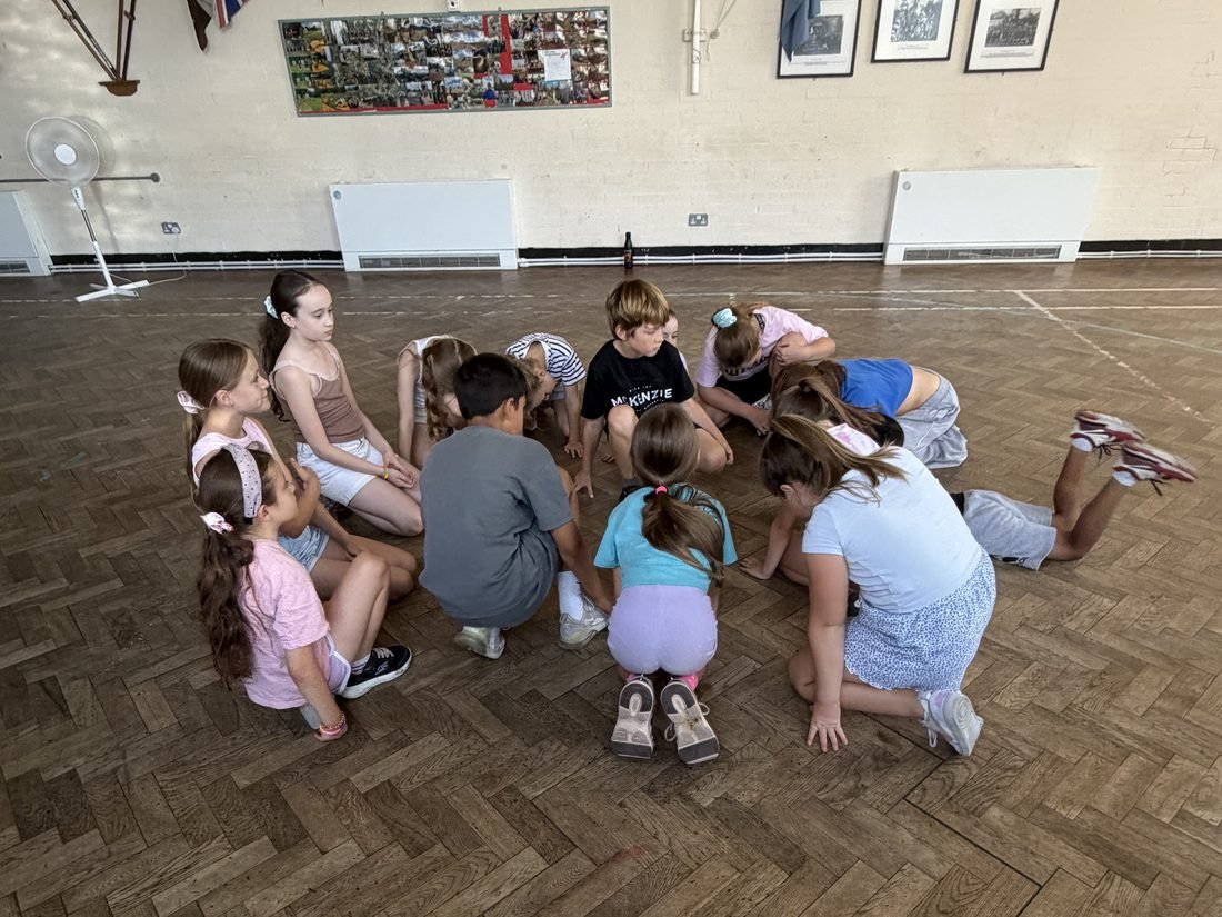 A group of young performers gathered together during a class exercise