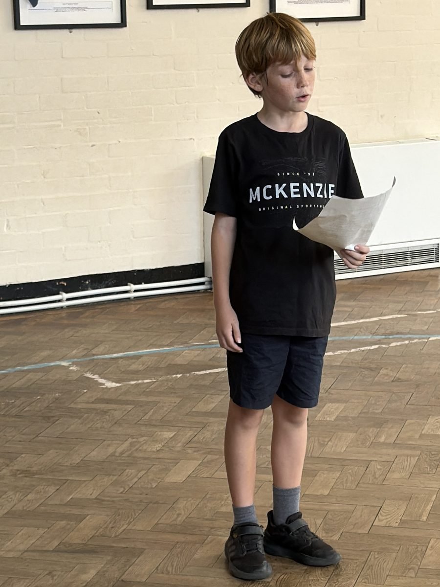 A young performer reading from a script during a class